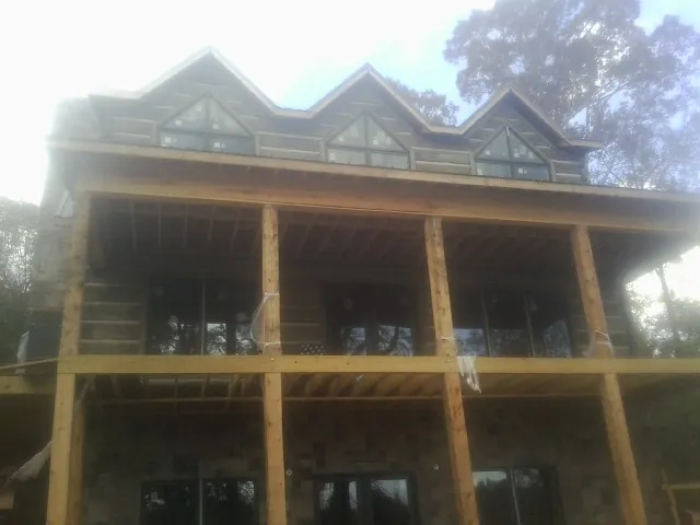 Dormers and porch framing on a large log home under construction — Roof Coating work by our crew in Sabillasville